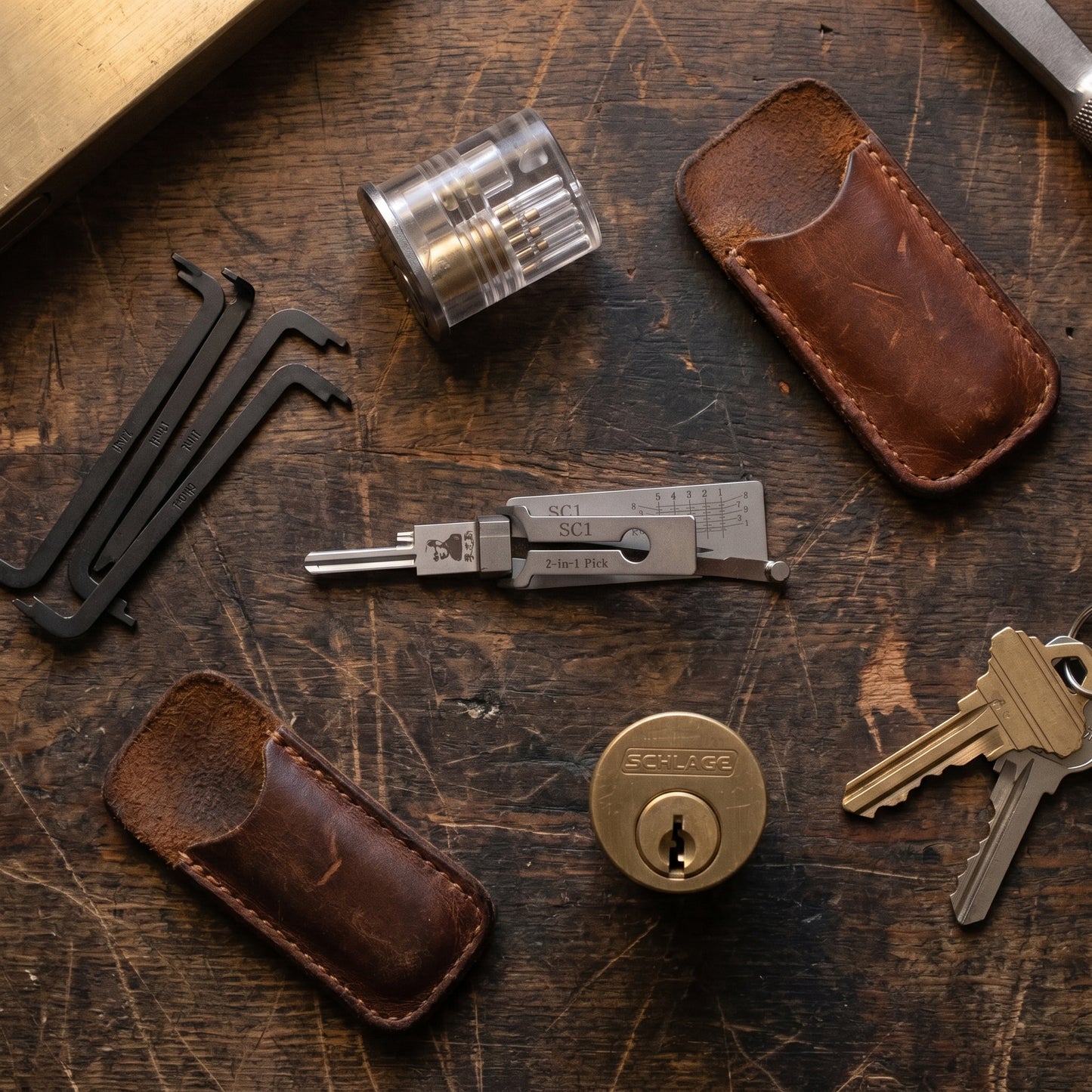 Pick and decoder on a workbench with tension wrenches, practice lock and keys